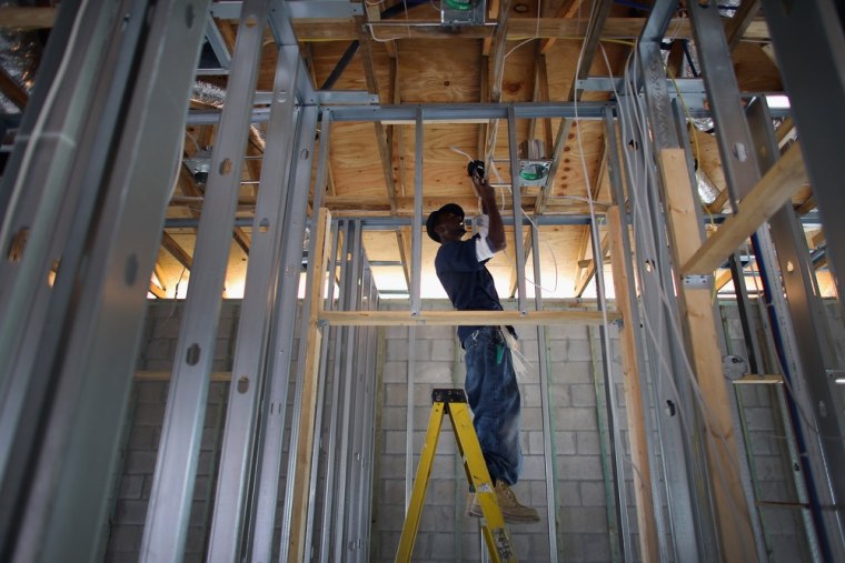 Electrician Calvin Warren helps build a Toll Brothers Inc. home in the Azura community on November 20, 2012 in Boca Raton, Florida. The economy is sho...