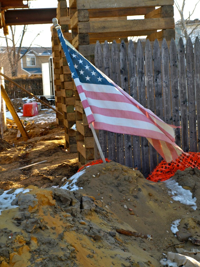 An American flag stands outside a home damaged by Hurricane Sandy.