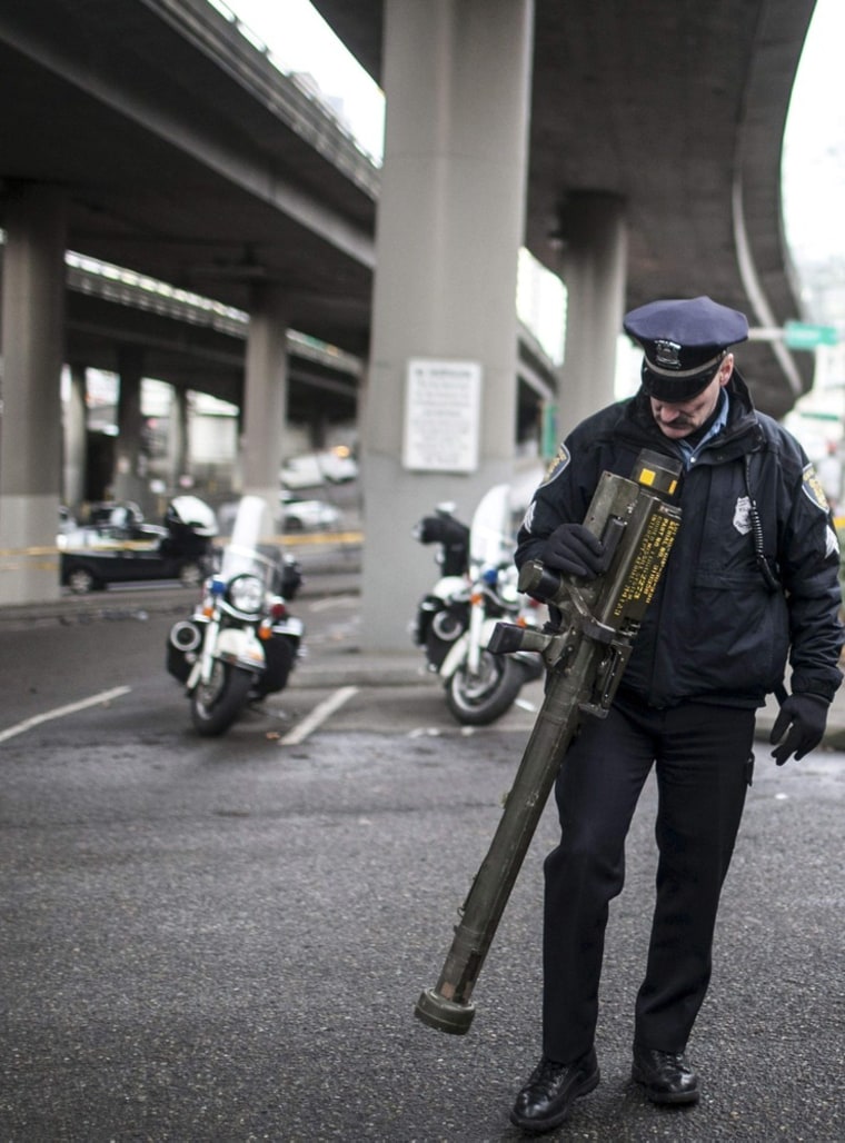 Seattle Police Department Sgt. Paul Gracy looks over a seized a missile launcher purchased outside a gun buyback event in Seattle, Wash., on Jan. 26.