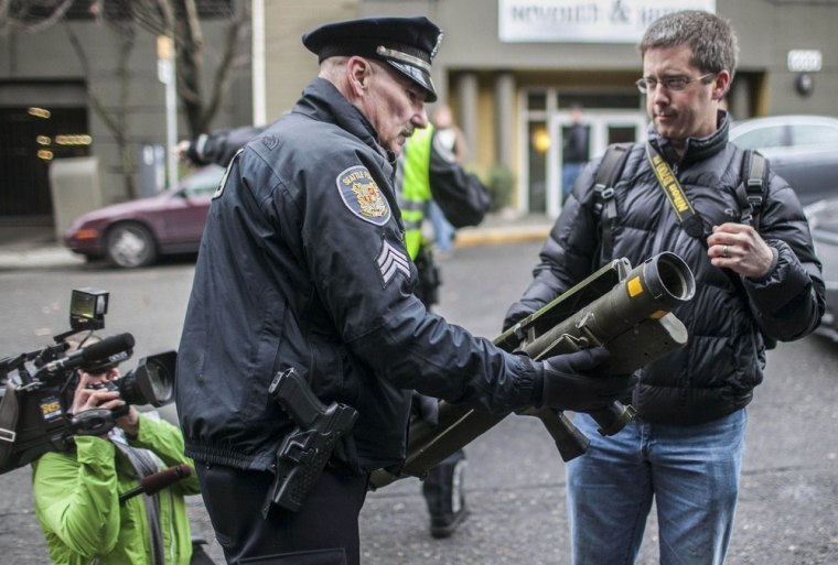 Seattle Police Department Sgt. Paul Gracy, left, seizes a missile launcher from Mason Vranish outside a gun buyback program in Seattle, Wash., on Jan. 26.