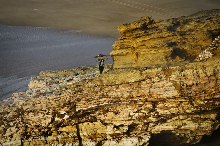 Hawaiian surfer Garrett McNamara carries his surfboard as he leaves the beach after a surf session at Praia do Norte in Nazare on Jan. 29.