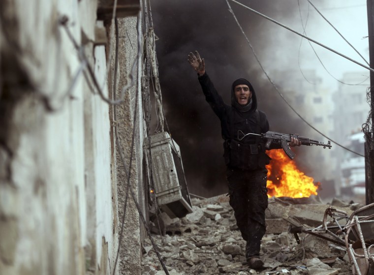 A Free Syrian Army fighter gestures in front of a burning barricade during heavy fighting in the Ain Tarma neighborhood of Damascus, on Jan. 30.