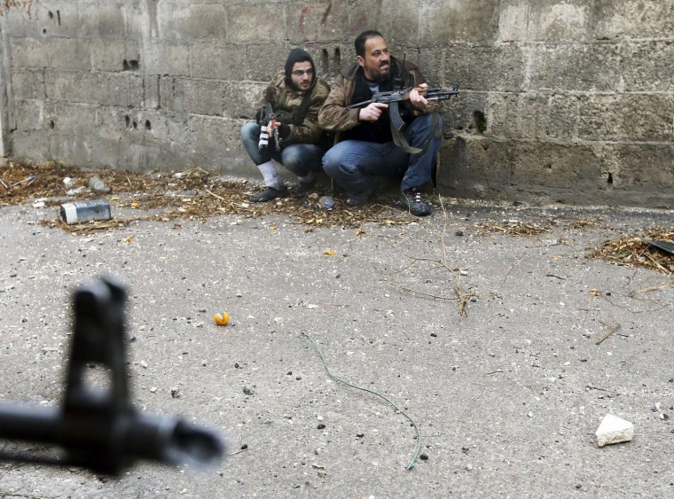 Free Syrian Army fighters take position just before they were hit by Syrian Army sniper fire during heavy fighting in the Ain Tarma neighborhood of Damascus, on Jan. 30. The fighter on the right died soon after, while his comrade was wounded.