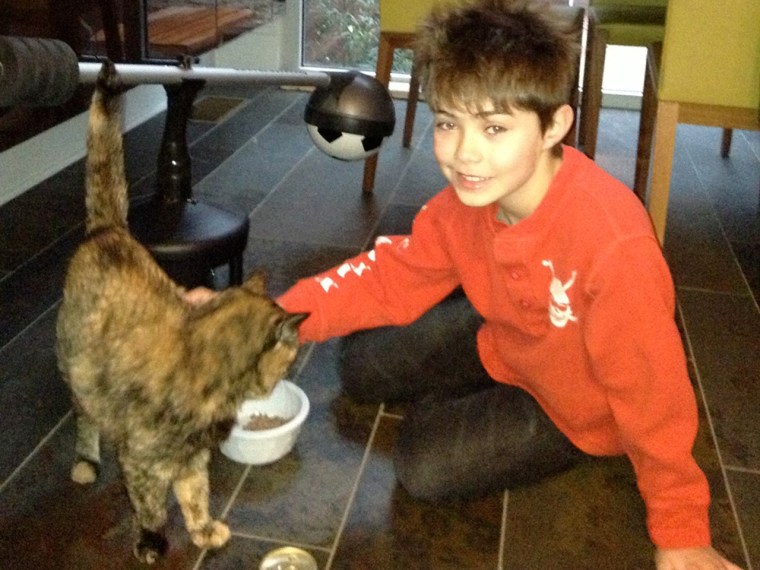 Saying goodbye: Natalie Morales's oldest son, Josh, enjoys a few last moments with their ailing cat, Emma.