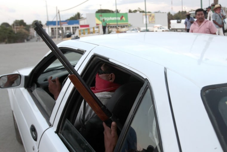 Armed men guard the Justice palace from a car, in Ayutla de los Libres, in the southern Mexican state of Guerrero, on Jan. 24.