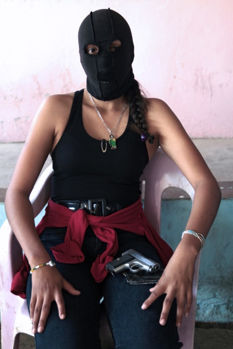 A female guard watches over 27 people arrested by a residents' police force in Ayutla de los Libres in the Guerrero state of Mexico on Jan. 25.