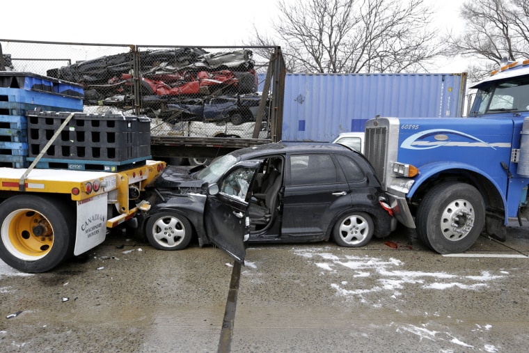 A car is jammed between two trucks after a mile-long pile-up on Interstate 75 in Detroit on Jan. 31.