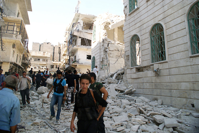 Rubble is strewn on the ground from a partially collapsed building after a rocket slammed into the side of a residential block beside a mosque in the northern city of Aleppo Saturday.