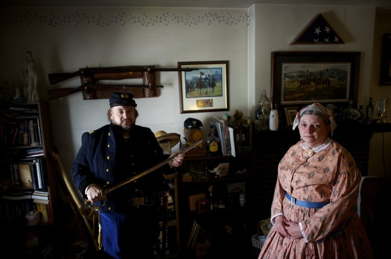 Clutching a cavalry saber, Ed Zamorsky, Union Army Lt. Colonel, and Chief Engineer of the GAC 150th reenactment, poses with his sister-in-law Julia Ann Sedlock, Camp Seamstress and 2nd Assistant Cook, in Zamorsky's Pottstown, PA residence on June 28, 2013.
