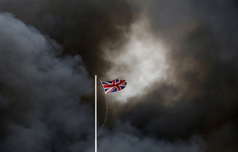 Smoke rises behind the Union Flag from a fire at a recycling plant in Smethwick, central England on July 1, 2013.