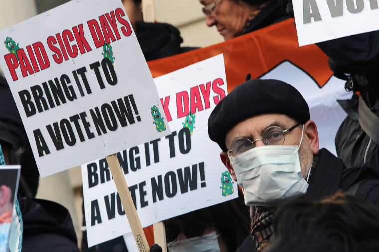 FILE- In this Friday, Jan. 18 2013 file photo, activists hold signs during a rally at New York's City Hall to call for immediate action on paid sick d...
