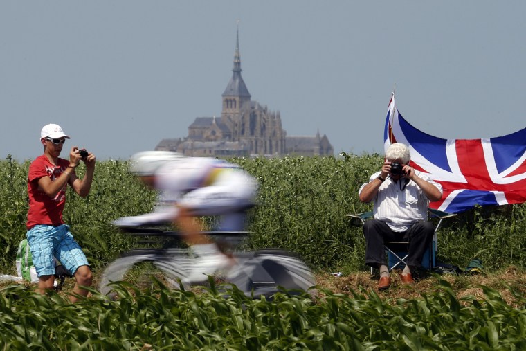 Tour de France bikers pass by Mont Saint-Michel