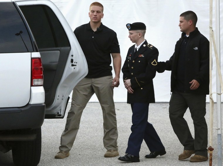 U.S. Army Private First Class Bradley Manning, center, is escorted out after a day of testimony at his court martial trial at Fort Meade, Md., on July 8.