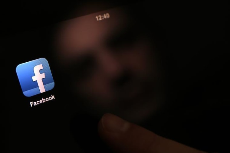 A man uses an iPad with a Facebook app in this photo illustration in Sofia January 30, 2013. REUTERS/Stoyan Nenov