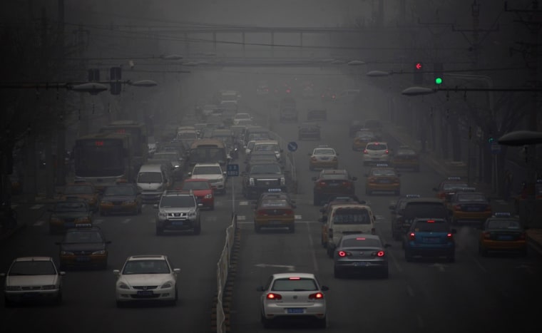 Cars drive along a street on a hazy day in Beijing January 29, 2013. Beijing temporarily shut down 103 heavily polluting factories and took 30 percent...