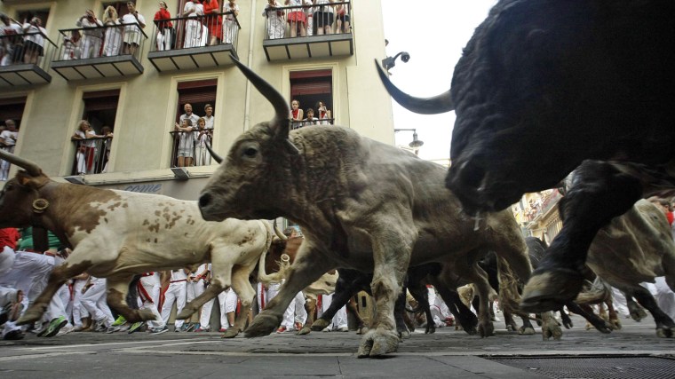 Torrestrella fighting bulls take the Estafeta curve during the fifth running of the bulls of the San Fermin festival on July 11.