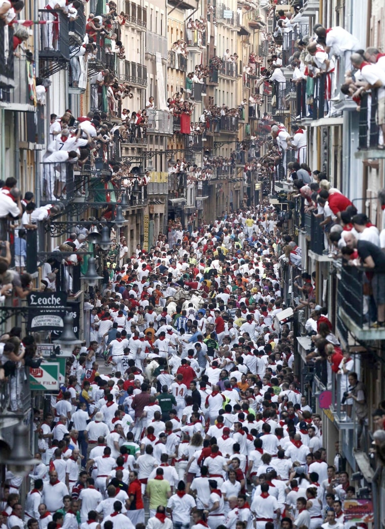 Runners or 'mozos' are chased by bulls from Torrestrella ranch in the Estafeta street, during the fifth bull run of the San Fermin festival in Pamplona, Spain, on July 11.
