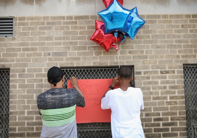 Fourteen-year-old Shyiem Wesley (R), and his father Dwight add to a makeshift memorial where his cousin was killed in Chicago.
