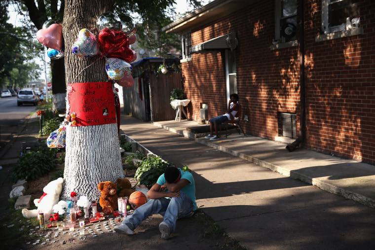A teenage boy grieves next to a makeshift memorial at the site where Ashley Hardmon was shot and killed on July 4 in Chicago. At least nine people were murdered over the holiday weekend.
