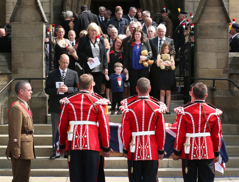 Members of Lee Rigby's family, including his son Jack and his wife Rebecca, watch as the soldier's coffin leaves Bury Parish Church after his military funeral in Bury, England, on July 12, 2013.