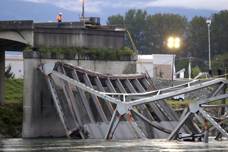 A worker looks at the collapsed portion of the Interstate 5 bridge at the Skagit River Friday, May 24, 2013, in Mount Vernon, Wash.