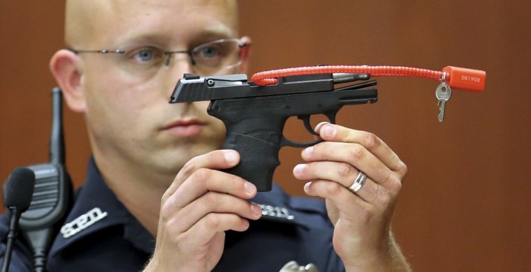 Sanford police officer Timothy Smith holds up the gun that was used to kill Trayvon Martin, while testifying during George Zimmerman's murder trial in Seminole circuit court in Sanford, Florida, June 28, 2013.