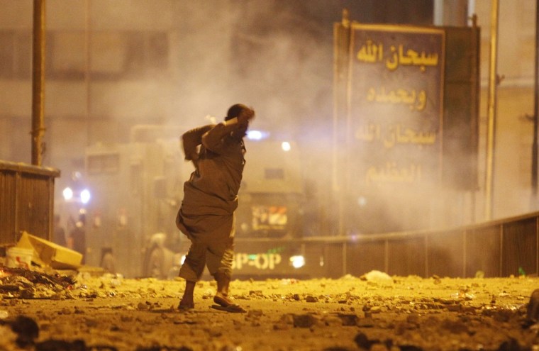 A supporter of deposed Egyptian president Mohammed Morsi throws stones at police during clashes on the 6th October Bridge and Ramses square in central Cairo early on Tuesday.