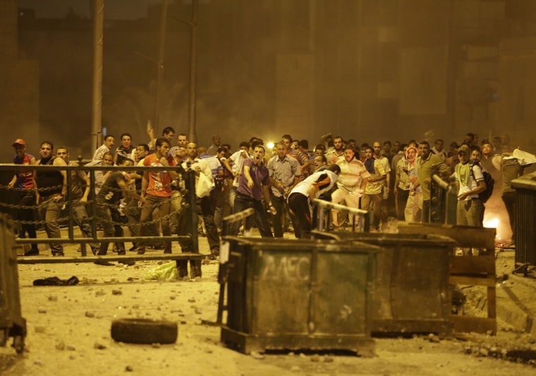 Supporters of ousted President Mohammed Morsi throw stones during clashes in downtown Cairo, Egypt, on Monday.