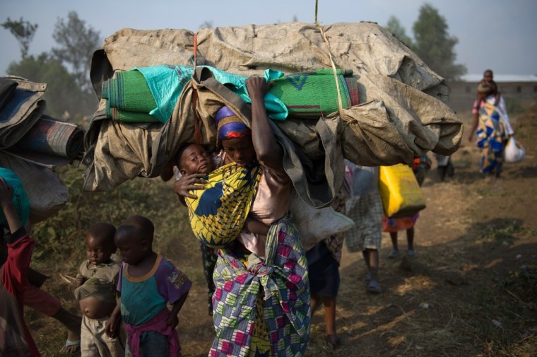 Displaced people flee the area of Kanyarucinya through Munigi, on the outskirts of Goma, on July 15, 2013.