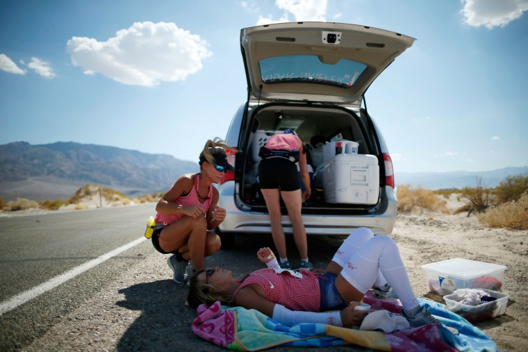 Shannon Farar-Griefer, 52, of Hidden Hills, California (lying down), is attended to by her team after stopping to drink water as she competes in the Badwater Ultramarathon in Death Valley National Park, Calif., on July 15, 2013.