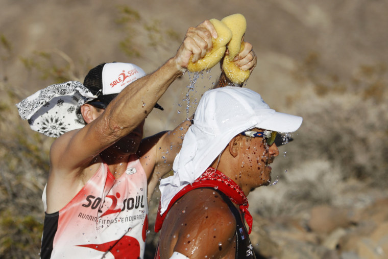 A crew member squeezes wet sponges over Oswaldo Lopez of Madera, Calif. during the AdventurCORPS Badwater 135 ultra-marathon race on July 15, 2013 in Death Valley National Park, Calif.