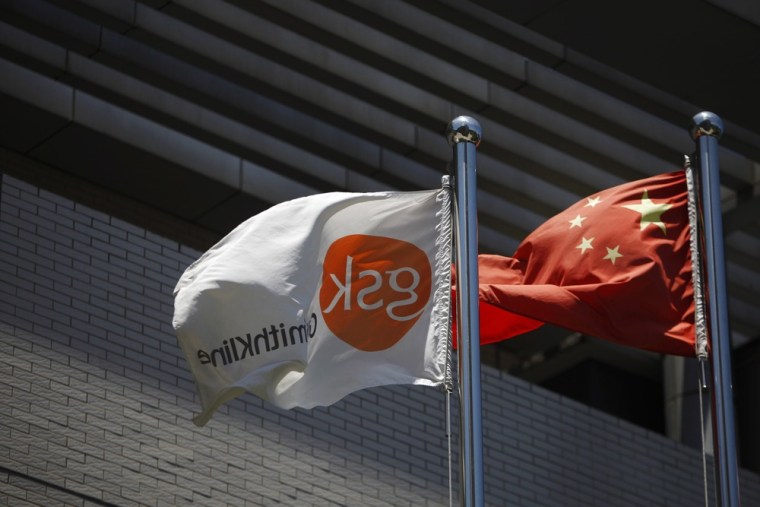 A flag (L) bearing the logo of GlaxoSmithKline (GSK) flutters next to a Chinese national flag outside a GlaxoSmithKline office building in Shanghai Ju...