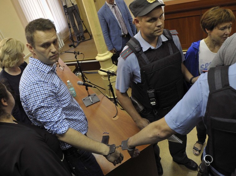 Russian protest leader Alexei Navalny is handcuffed and escorted by Interior Ministry officers inside a courtroom in Kirov on Thursday.