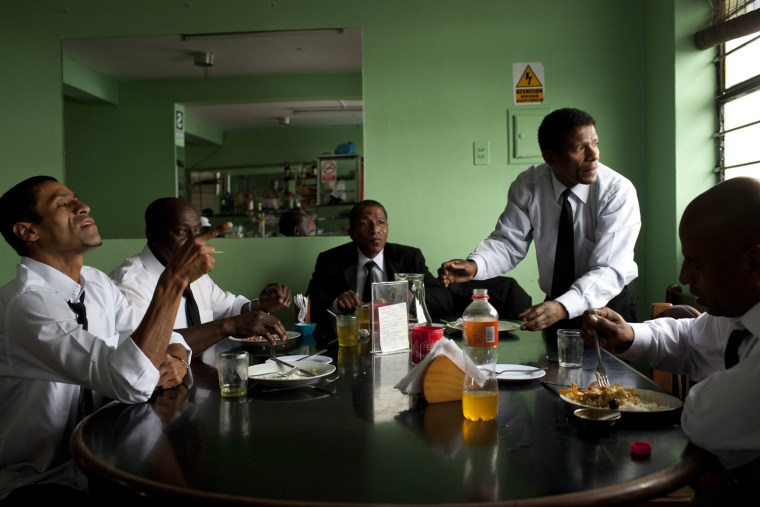 A group of pallbearers eat lunch before working at a burial in Lima on July 2, 2013. Black pallbearers are a legacy, historians say, of the concentration in Lima of the bulk of Spain's colonial nobility in the Americas, a segment of the population that routinely had a sizable retinue of house slaves.