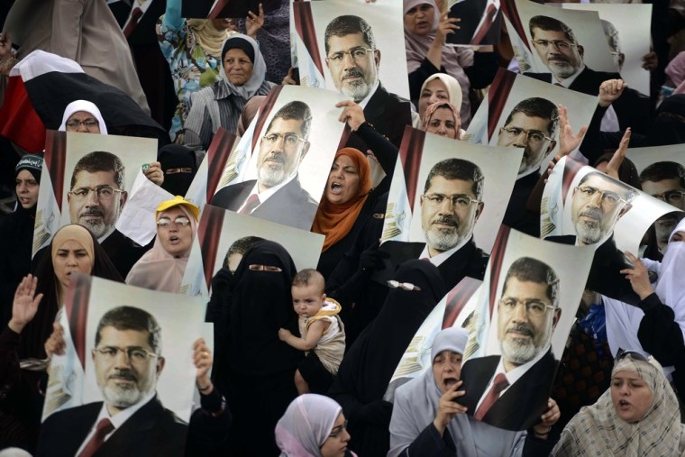 Female Egyptian supporters of the Muslim Brotherhood hold up portraits of Egypt's ousted president Mohamed Morsi during a rally in Cairo on July 21, 2013. Supporters of Morsi, who has been held in custody since his ouster on July 3, view the army's decision to overthrow the man they voted into power last year as an affront to democracy.