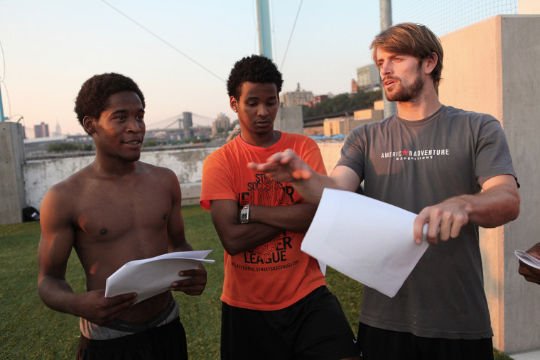 Coach Eric talks with players Tyshor Figueroa, left, and Jericho about an upcoming tournament after a Street Soccer game in Brooklyn Bridge Park on July 17 in New York City.