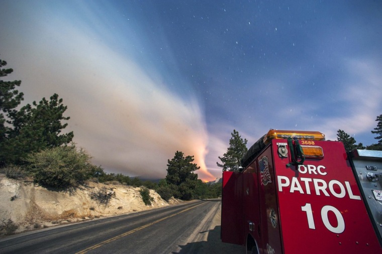 A long exposure picture shows an Orange County Fire Authority Crew keeping watch in a residential area of Idyllwild, USA, 19 July 2013, as the Mountain Fire burns three km away. Some 6,000 residents of the mountain town of Idyllwild and the surrounding communities some 180 km east of Los Angeles were evacuated.