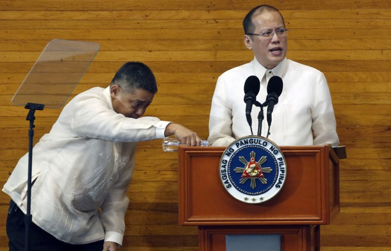 A presidential aide pours water for Philippine President Benigno Aquino as Aquino delivers his fourth State of the Nation Address (SONA) at the House of Representatives in Quezon City, Metro Manila July 22, 2013.