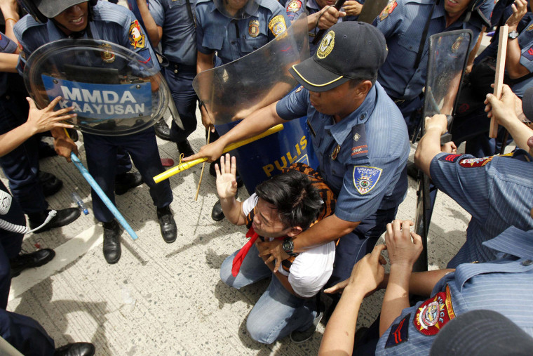Filipino anti-riot policemen clash with protesters attempting to reach the Philippine Congress in Quezon City, hours before the address by President Benigno Aquino III.