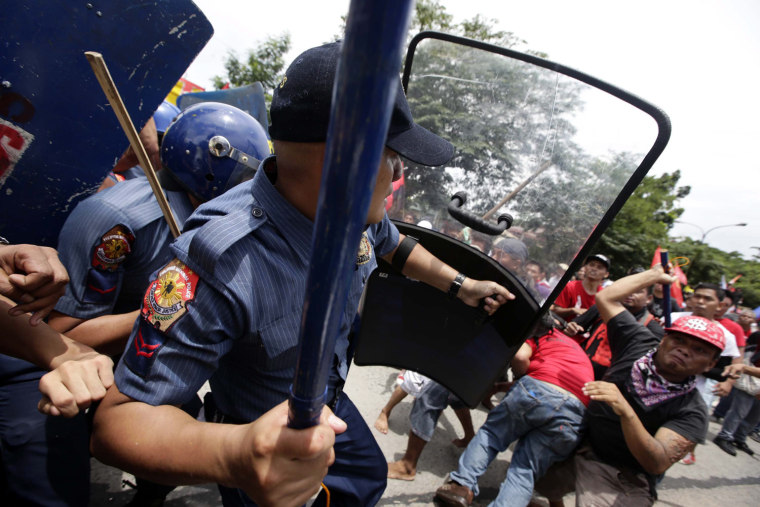 Filipino anti-riot policemen clash with protesters attempting to reach the Philippine Congress in Quezon City, hours before the State of the Nation address.