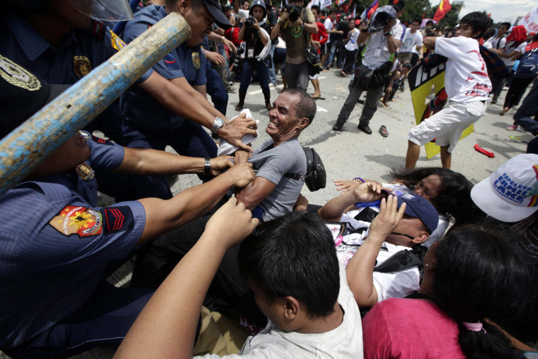Filipino anti-riot policemen clash with protesters attempting to reach the Philippine Congress in Quezon City, ahead of the State of the Nation address by Philippine president Benigno Aquino III.