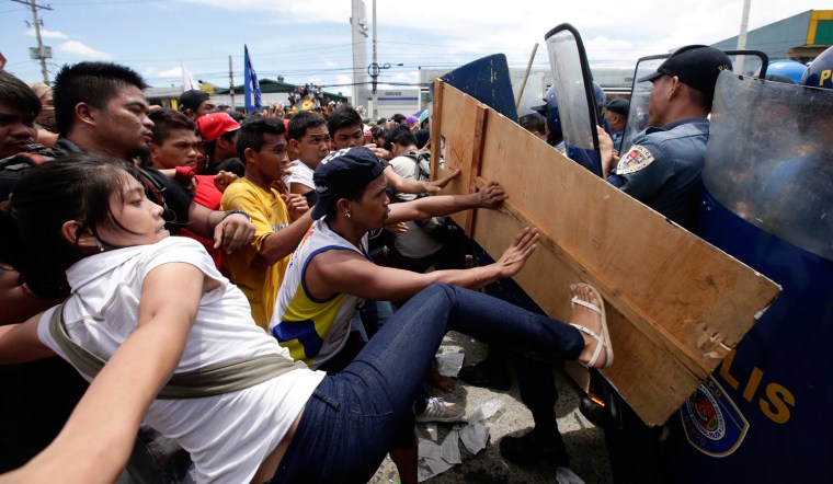Filipino anti-riot policemen clash with protesters attempting to reach the Philippine Congress in Quezon City, east of Manila, Philippines, July 22, 2013. Dozens of protesters and police were injured in clashes ahead of President Aquino III's State of the Nation address.