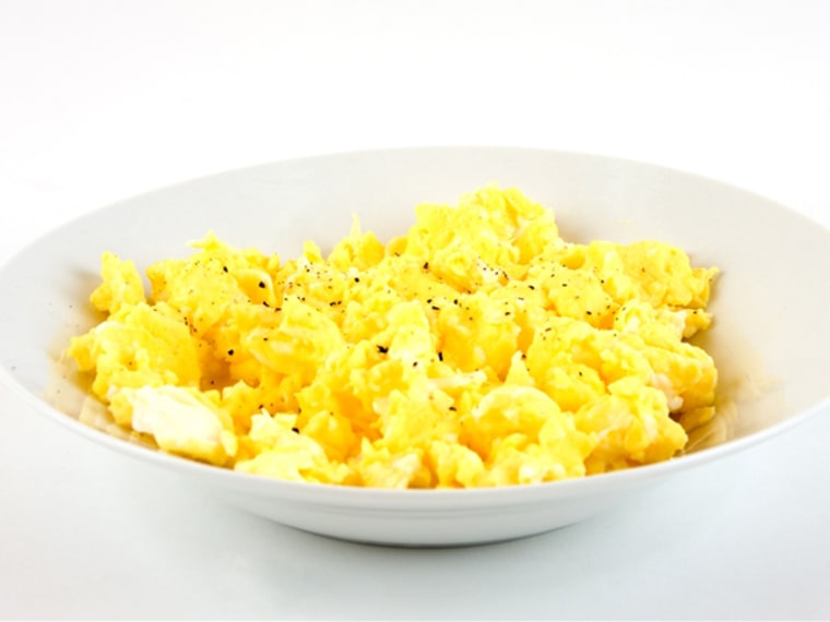 A bowl of scrambled eggs with cracked pepper