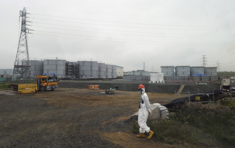 A construction worker walks beside the underground water tanks at the Fukushima Dai-ichi nuclear plant at Okuma in Fukushima prefecture, Japan.