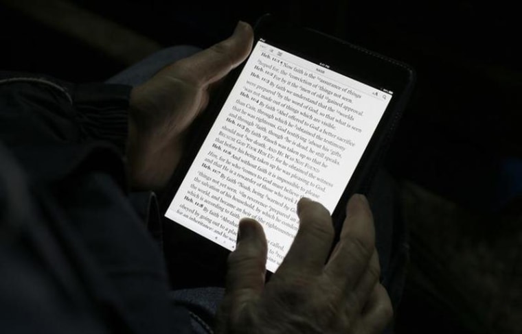 A man reads the bible from an iPad mini at the