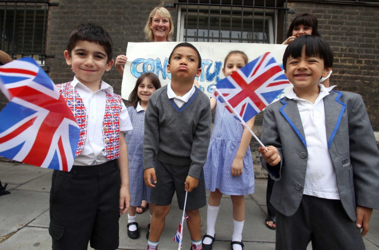 Children from a local school wave British flags outside St. Mary's hospital in London on July 23, 2013, to celebrate the arrival of the royal baby.