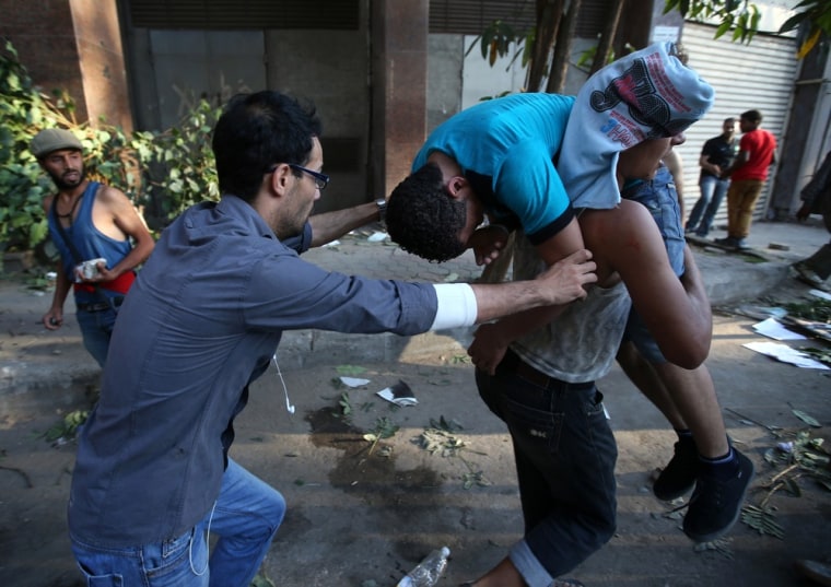 Opponents of ousted President Mohammed Morsi carry their injured friend who was wounded during clashes with Morsi supporters in Cairo on Monday.