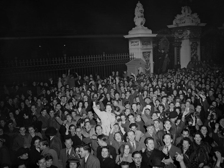 A jubilant crowd mass around the gates of Buckingham Palace, London, on Nov. 14, 1948, cheering the announcement of the birth of a prince to Princess ...