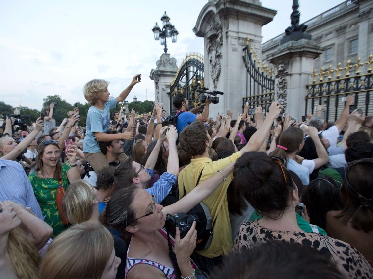 Image: Crowds try to look at a notice formally announcing the birth of a son to Britain's Prince William and Catherine, Duchess of Cambridge, in the forecourt of Buckingham Palace in London on July 22, 2013.