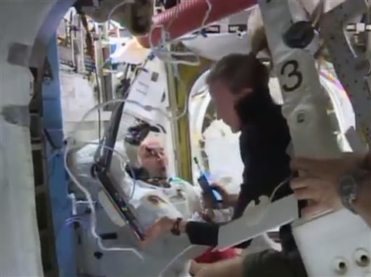 In this image from video made available by NASA, astronaut Karen Nyberg assists astronaut Luca Parmitano remove his space suit after the aborted space...